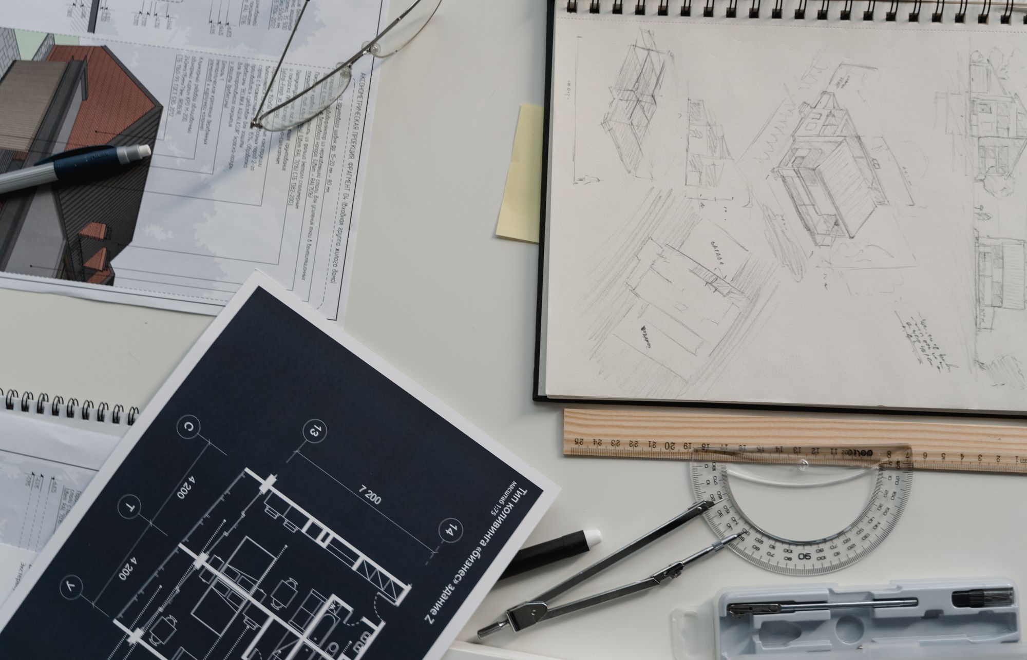 Plans d’exécution, compas et équerre posés sur une table de travail