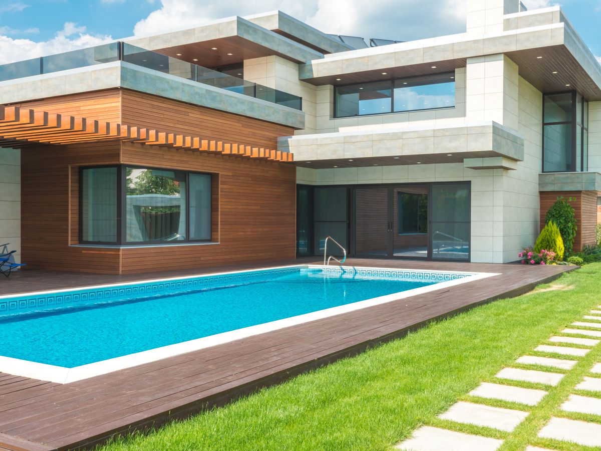 Maison contemporaine ouvrant sur une piscine rectangulaire et une pelouse