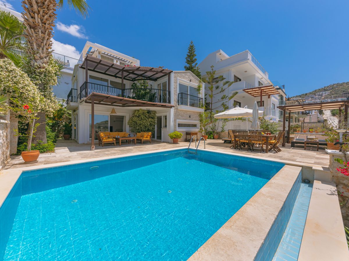 Piscine et terrasse d’une villa entourée de végétation